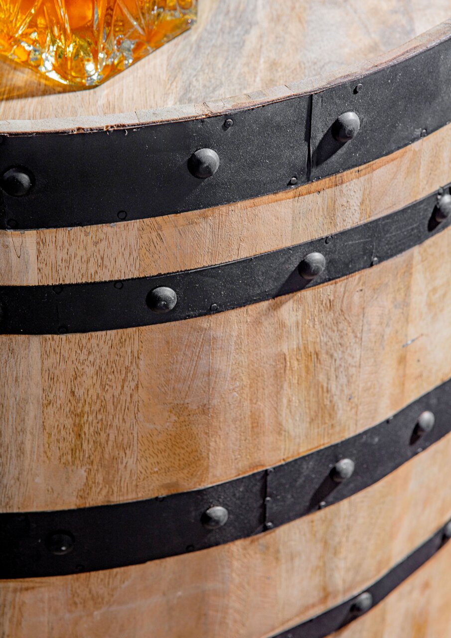 Nahaufnahme eines rustikalen Holzfasses mit schwarzen Metallbändern, von oben betrachtet.