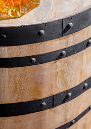 Nahaufnahme eines rustikalen Holzfasses mit schwarzen Metallbändern, von oben betrachtet.