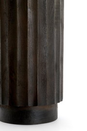Nahaufnahme eines dunkel gebeizten, geriffelten Holzobjekts mit zylindrischem Sockel, frontal aus seitlicher Perspektive vor weißem Hintergrund