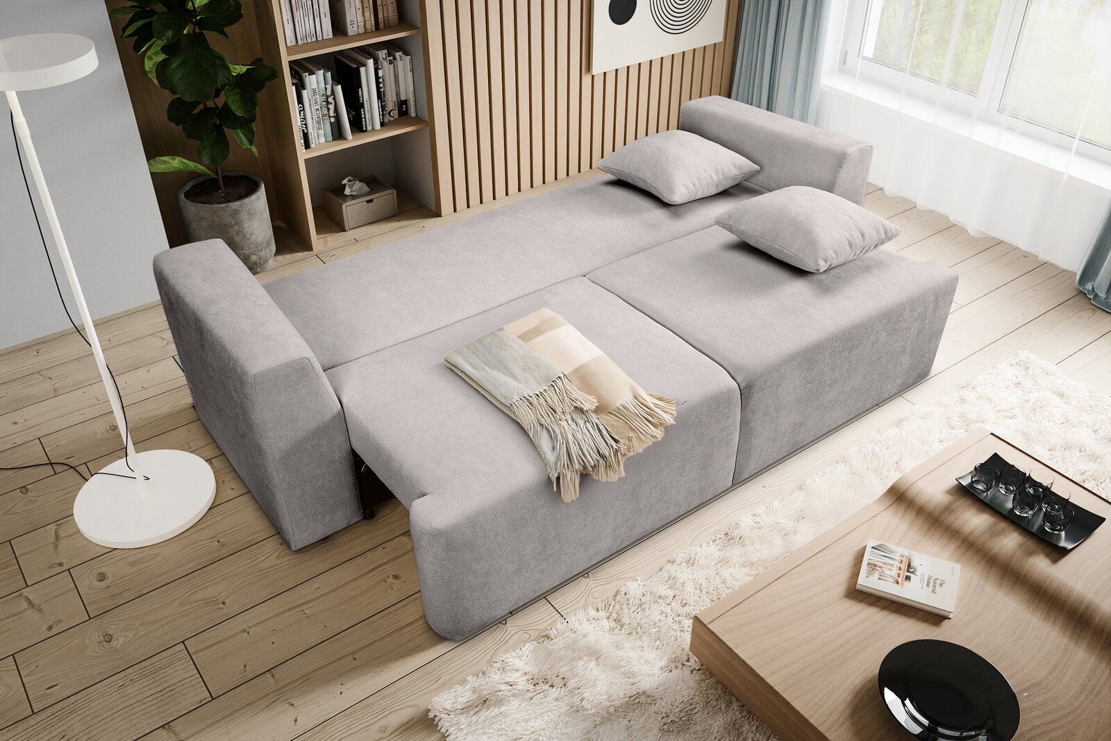 Modernes hellgraues Schlafsofa mit ausgeklappter Liegefläche und zwei Kissen im Wohnzimmer, Draufsicht aus schräger Vogelperspektive