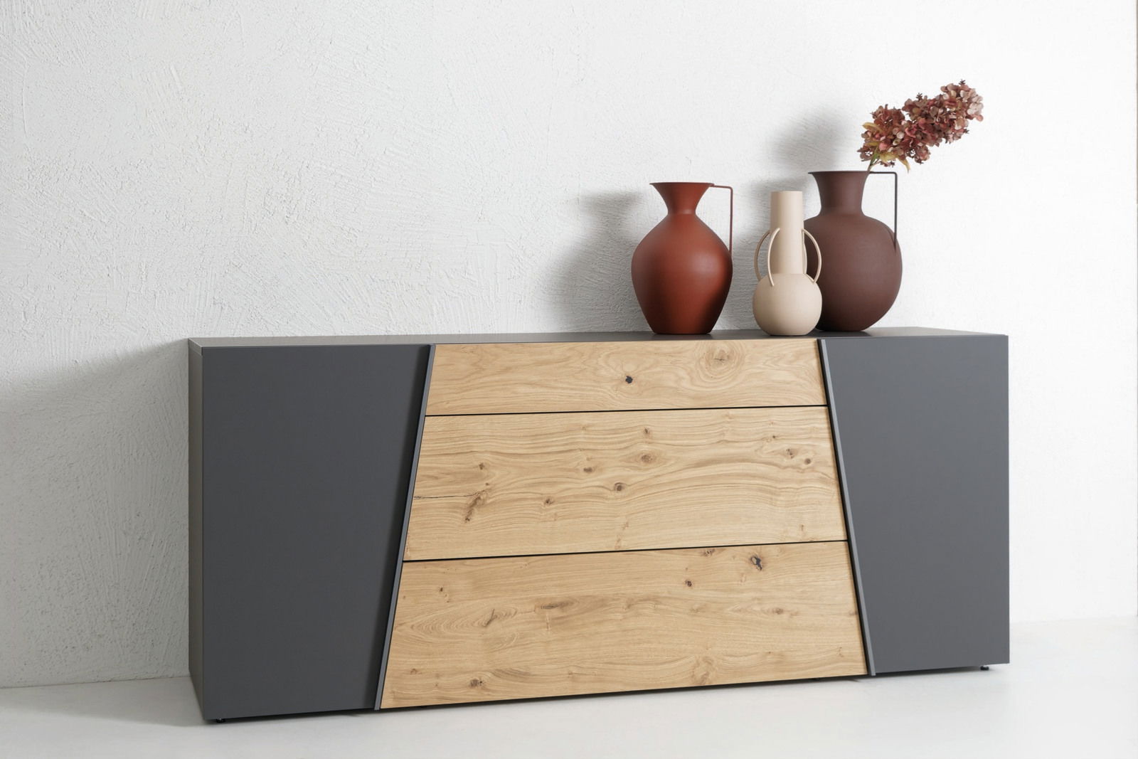 Modernes Sideboard mit grauen Seiten und Holzfront, dekoriert mit drei Vasen, aus frontaler Perspektive.