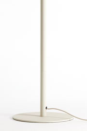 Nahaufnahme des unteren Teils einer Stehleuchte mit rundem Sockel und Stromkabel, seitliche Perspektive.