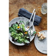 Salatbesteck NUOVA 25cm aus Edelstahl, auf einem Tisch mit einem frischen Salat in einer Schale, von oben fotografiert.