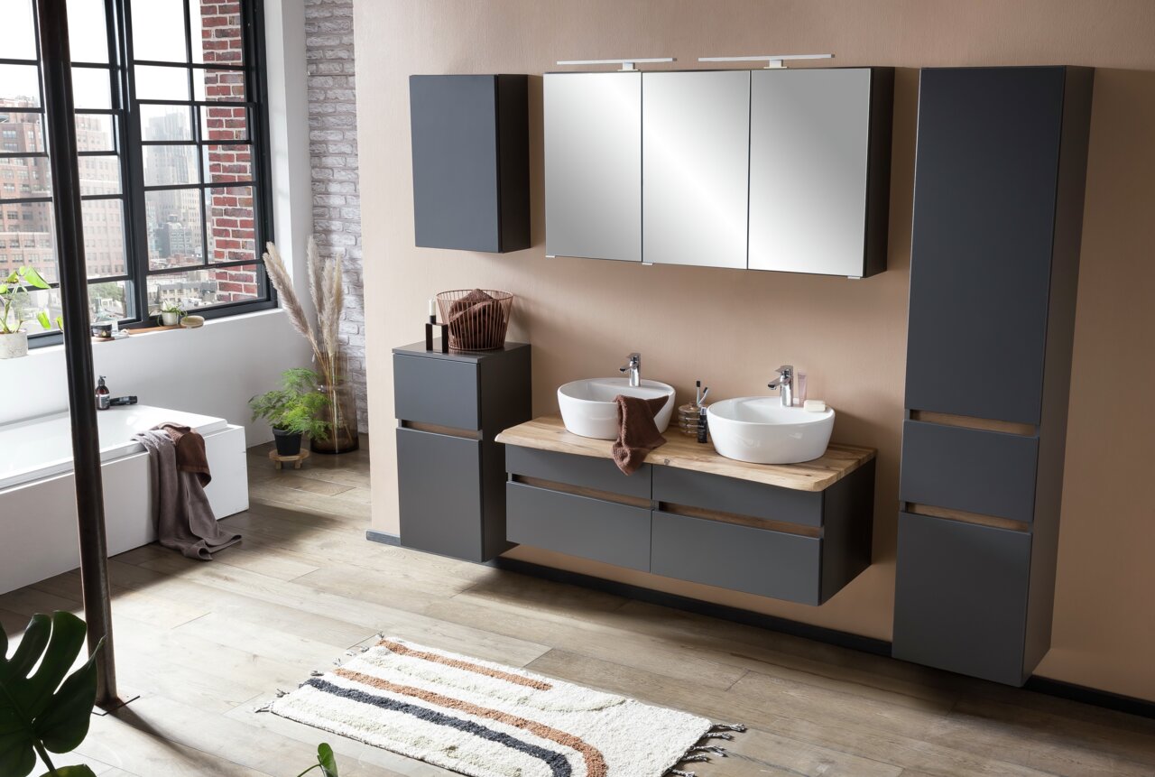 Modernes Waschtisch-Set in einem stilvollen Badezimmer mit zwei Waschbecken, dunklen Schränken und einem großen Spiegel, aus der Perspektive des gesamten Raumes betrachtet.