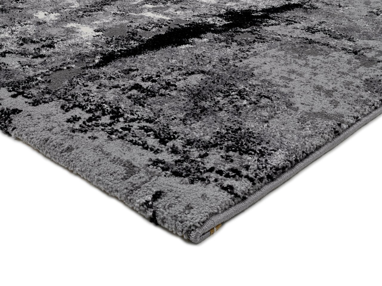 Nahaufnahme eines grauen Teppichs mit abstraktem Muster, perspektivisch von der Seite aufgenommen.