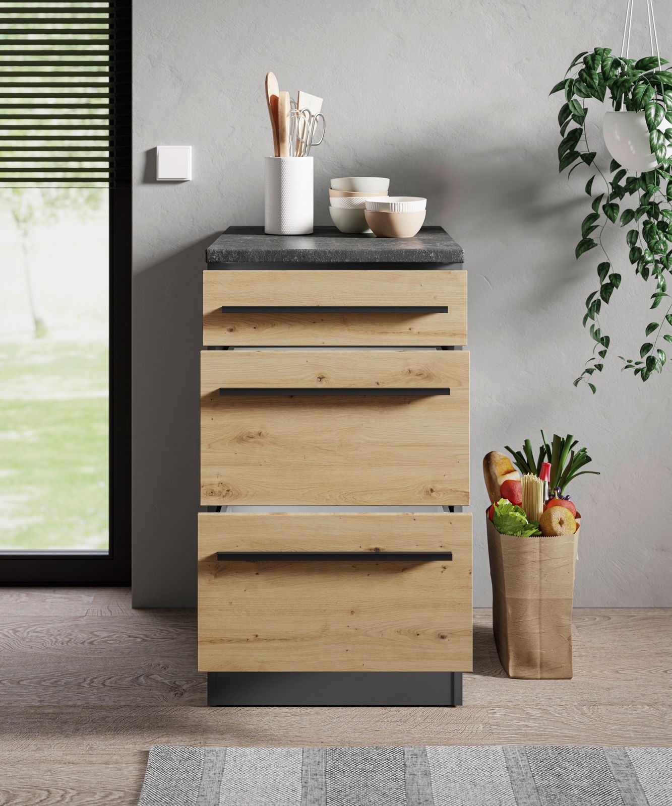 Moderner Unterschrank aus Holz mit drei Schubladen, schwarze Griffe, graue Arbeitsplatte, Frontansicht.