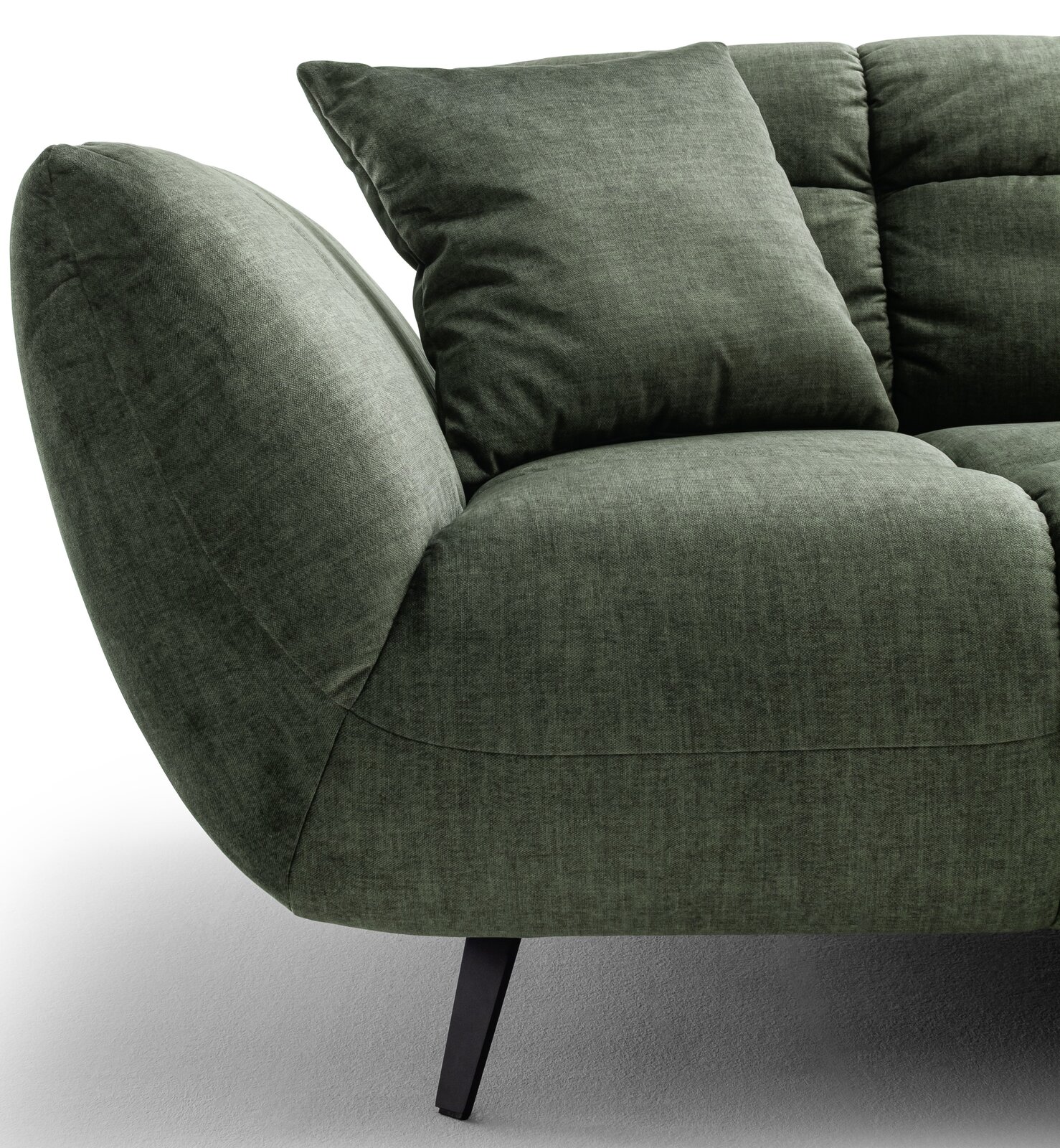 Detailansicht eines grünen Stoffsofas mit abgerundeter Armlehne, Sitzkissen und Rückenkissen auf schwarzen Metallfüßen, Perspektive schräg von vorne links
