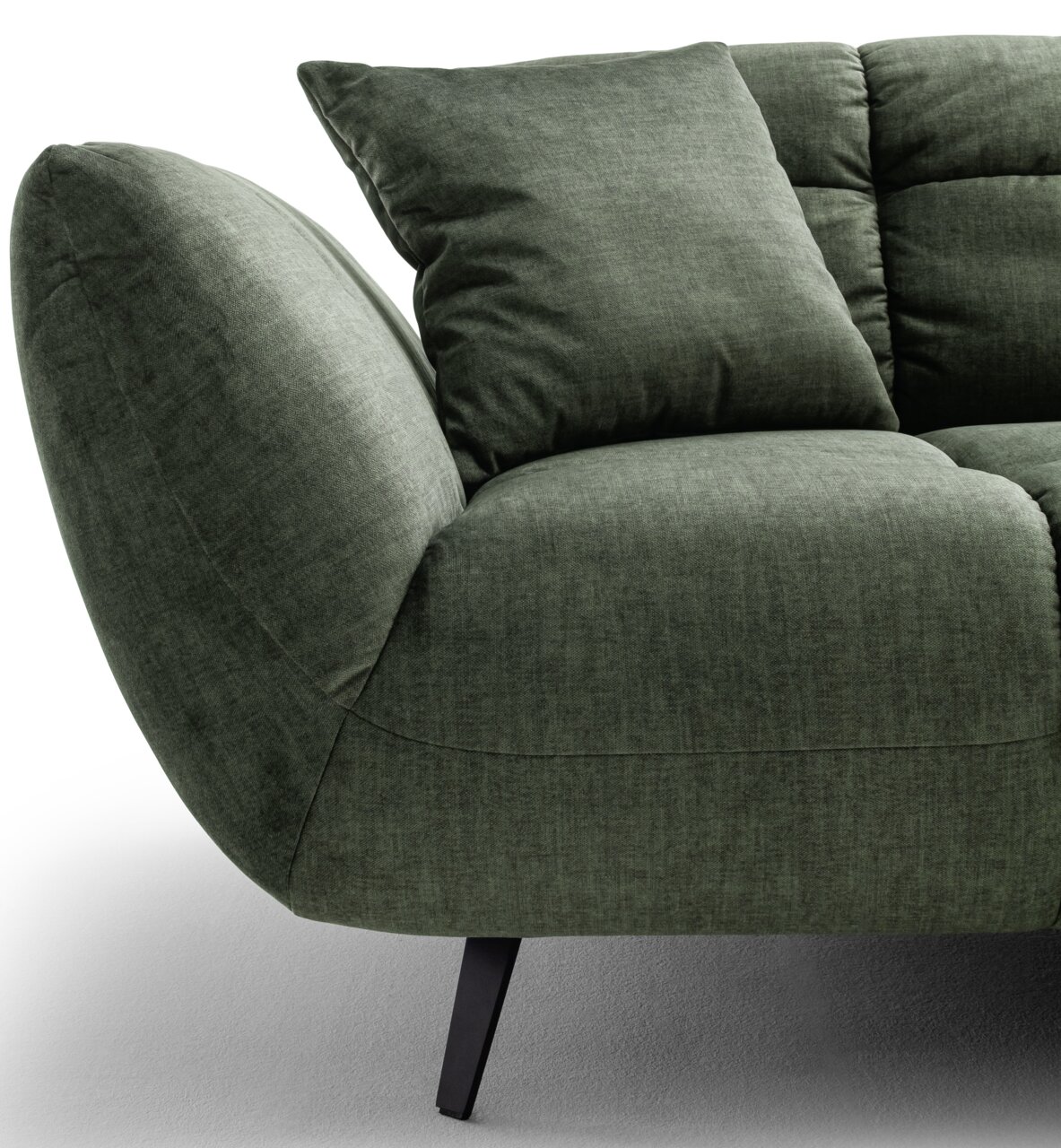 Detailansicht eines grünen Stoffsofas mit abgerundeter Armlehne, Sitzkissen und Rückenkissen auf schwarzen Metallfüßen, Perspektive schräg von vorne links