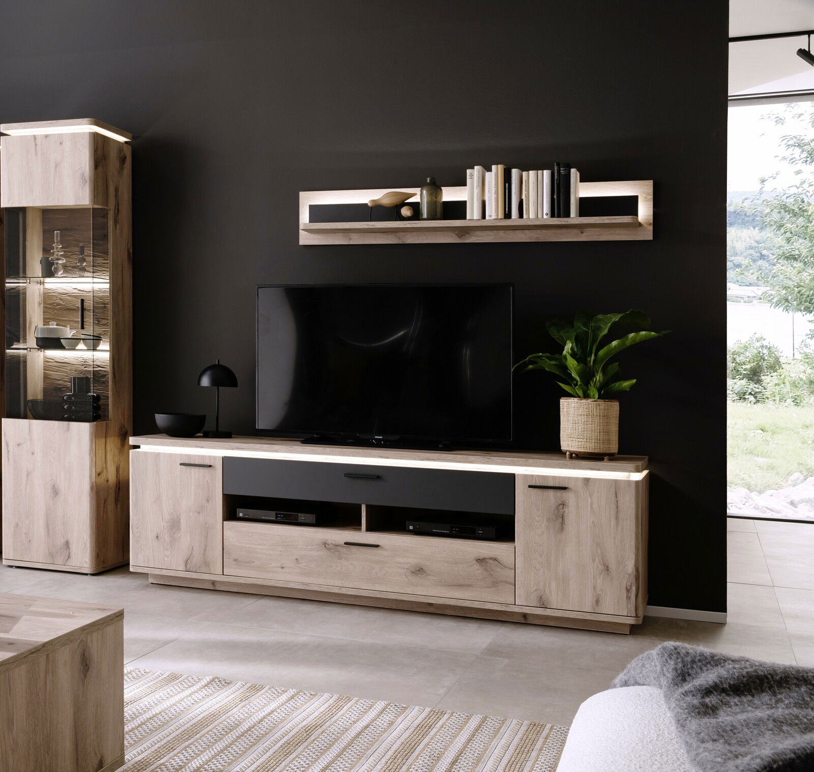 Moderne Wandkombination in Holzoptik mit TV-Schrank, Regal und Vitrine, seitliche Perspektive.