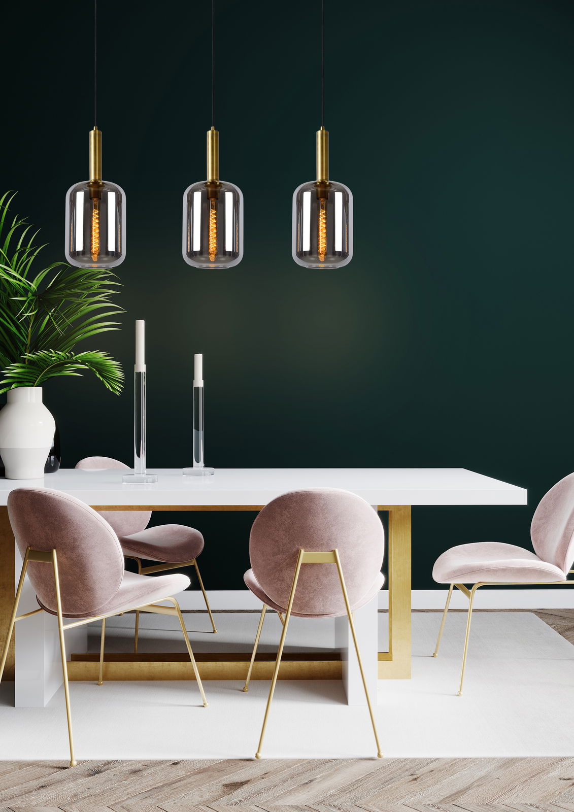 Drei moderne Pendelleuchten JOANET mit goldenen Akzenten hängen über einem eleganten Esstisch mit rosa Samtstühlen, seitliche Perspektive.