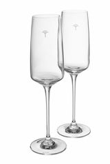 Zwei elegante Champagnergläser aus klarem Glas mit langem Stiel, von der Seite betrachtet, mit dezentem Logo auf dem Kelch.