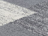 Nahaufnahme eines Frisé-Teppichs in Grau- und Weißtönen mit strukturierter Oberfläche.