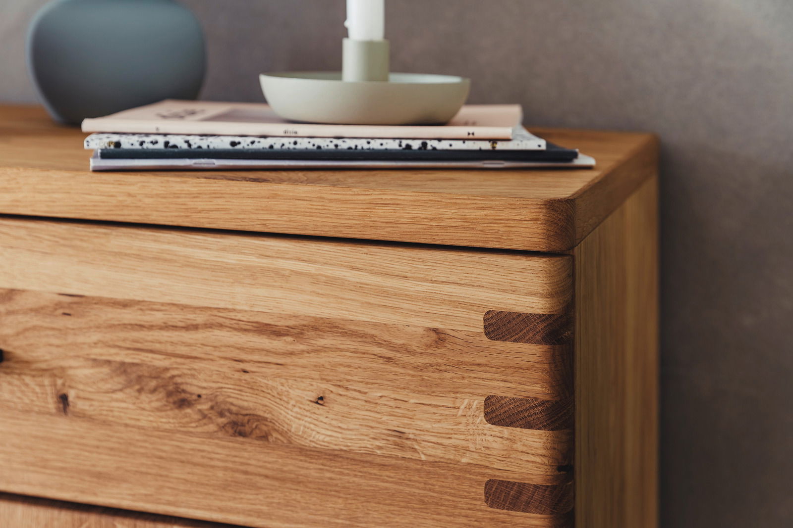 Nahaufnahme einer hölzernen Kommode mit sichtbaren Schwalbenschwanzverbindungen, von der Seite betrachtet.