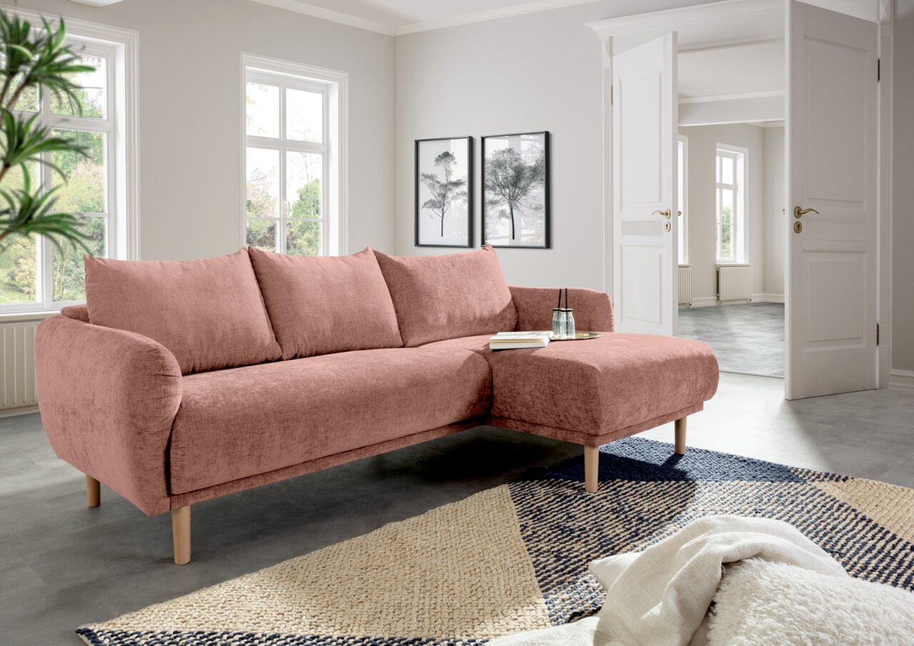 Rosa Ecksofa mit Ottomane in einem modernen Wohnzimmer, seitliche Perspektive