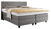 Graues Boxspringbett mit gestepptem Kopfteil, seitliche Perspektive