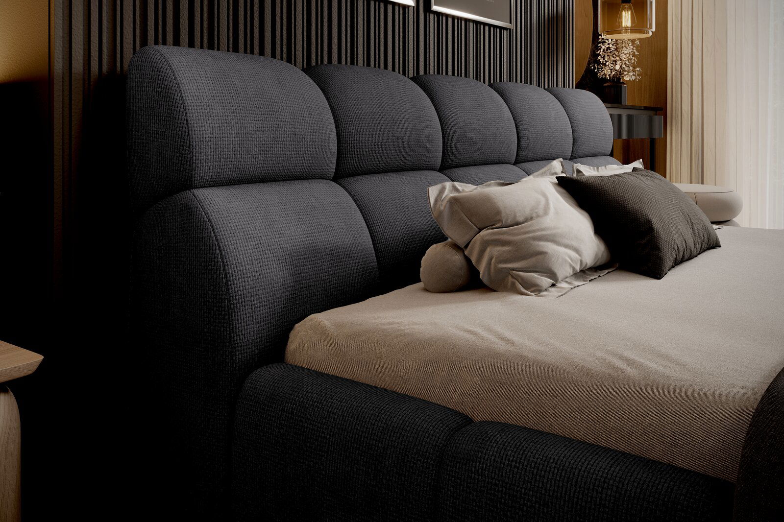 Seitliche Perspektive auf ein elegantes Polsterbettgestell mit dunkelgrauem Kopfteil und bequemen Kissen.
