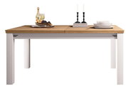 Moderner Esstisch mit weißem Gestell und Holzplatte, dekoriert mit Kerzen, Geschirr und Obst, Frontalansicht.