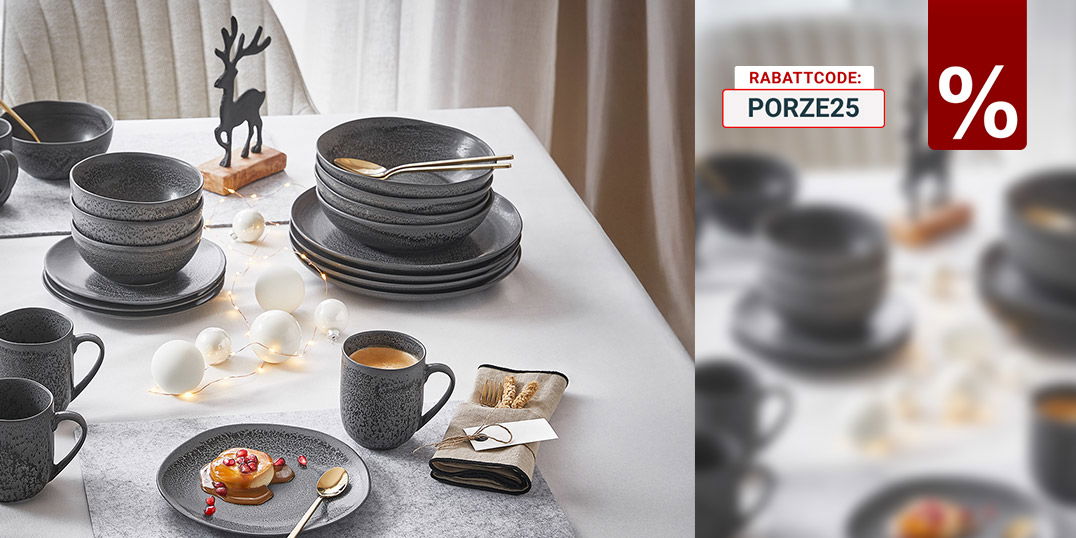 Festlich gedeckter Tisch mit dunkelgrauem Geschirr, Heißgetränken, Deko-Lichtern und kleinem Rentier als winterliche Tischdeko