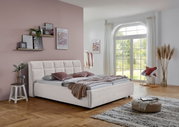 Modernes Polsterbett in einem stilvoll eingerichteten Schlafzimmer, seitliche Perspektive