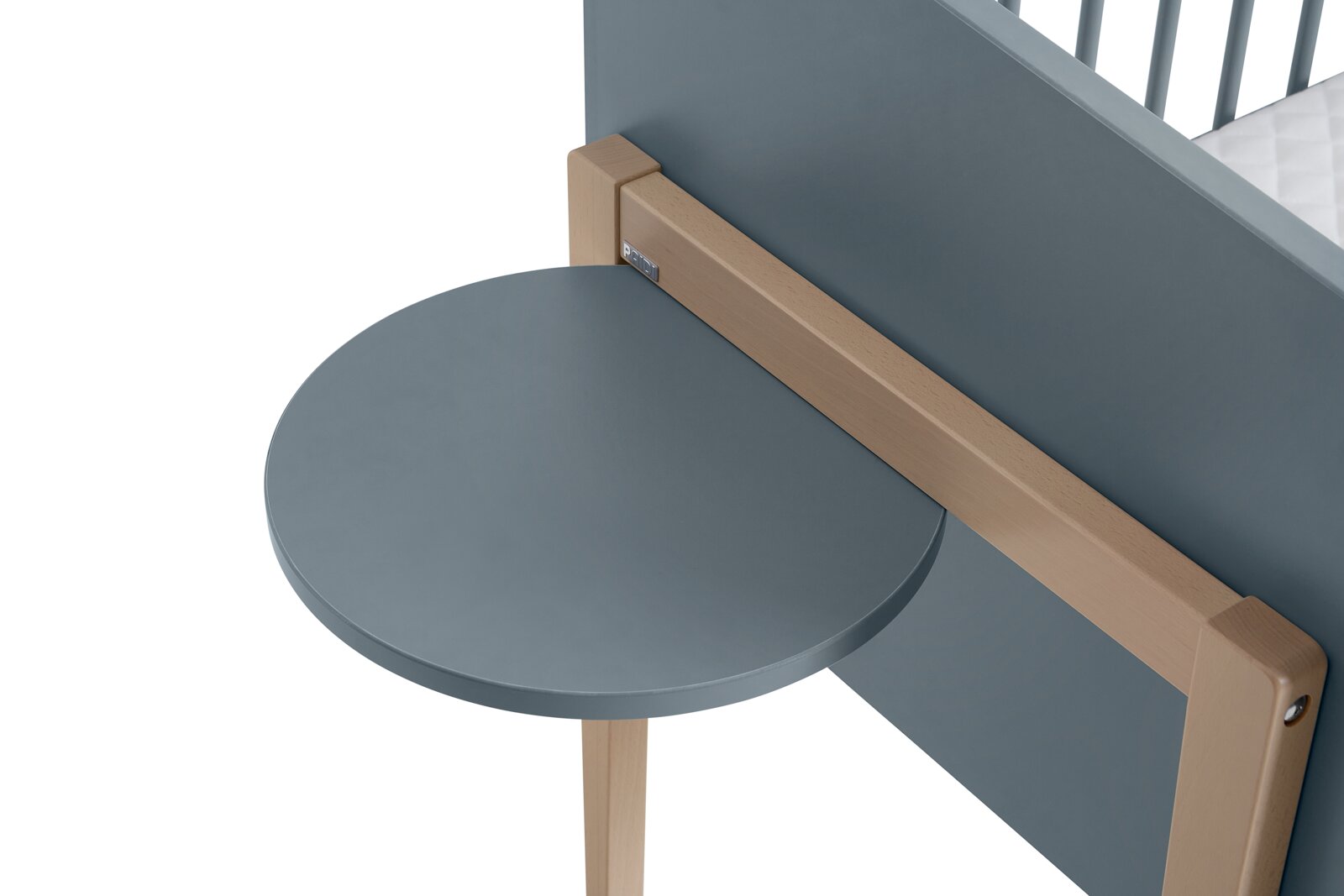 Ronde, grijze houten plank, aan de zijkant van een meubelstuk bevestigd, gezien vanuit vogelperspectief.