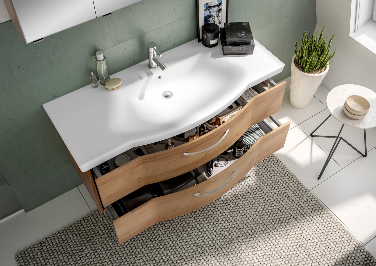 Moderne wastafel met een gebogen witte wasbak en twee open houten lades, vogelperspectief