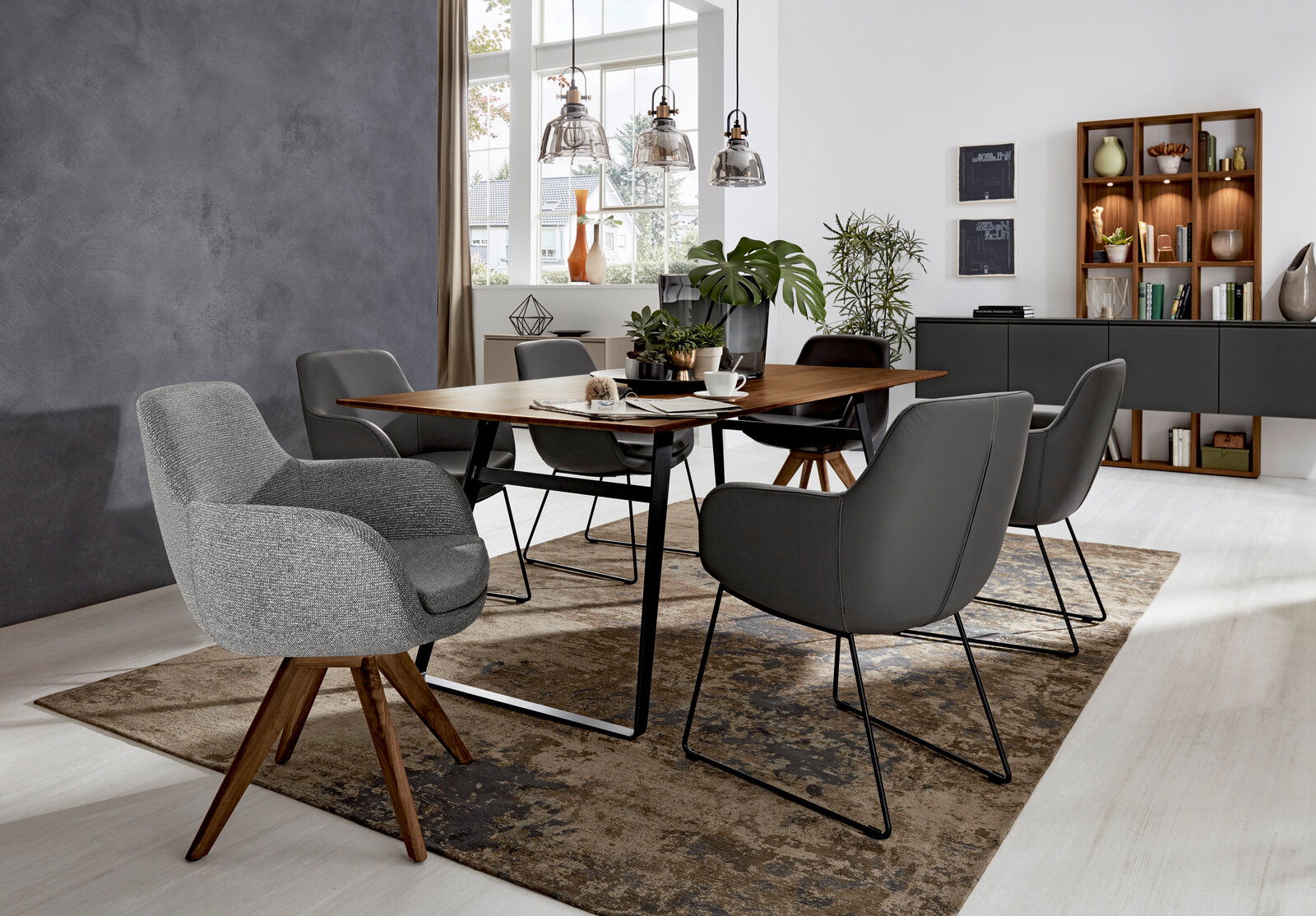 Musterring Armlehnstuhl MR TAVIA Moderner Essbereich mit grauen Armlehnstühlen um einen Holztisch, seitliche Perspektive