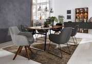Moderne eethoek met grijze stoelen met armleuningen rond een houten tafel, zijaanzicht