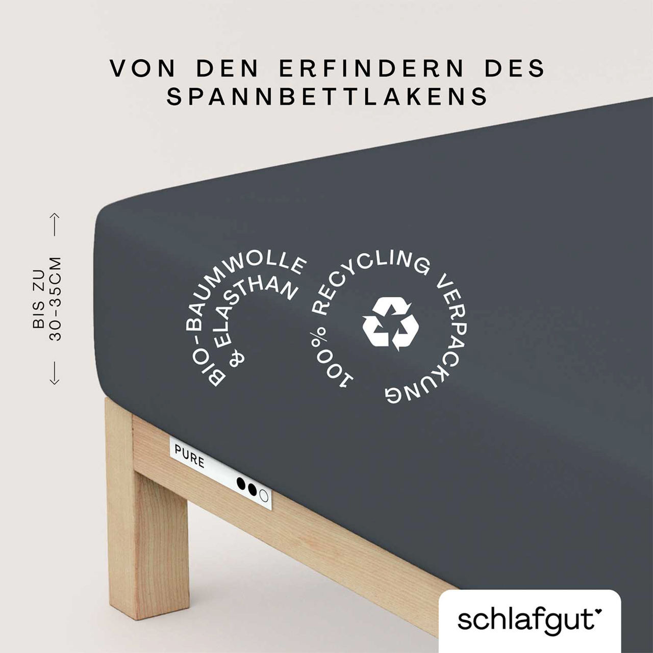 Spannbettlaken aus Bio-Baumwolle und Elasthan in dunkler Farbe, auf einem Bett mit Holzrahmen. Verpackung aus 100% Recyclingmaterial. Perspektive von der Seite.