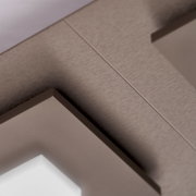 Detailaufnahme eines taupefarbenen Ausziehtisches mit fein strukturierter Tischplatte und präziser Mittelfuge aus schräger Untersicht