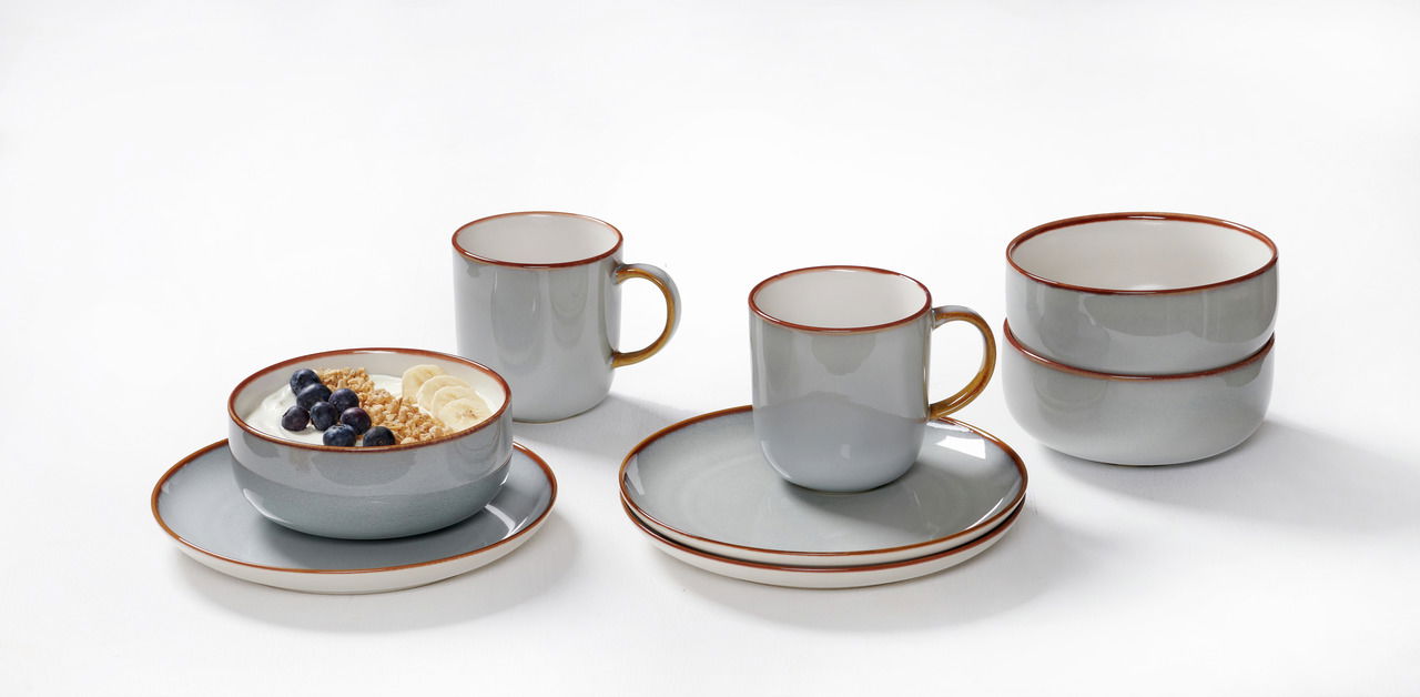 Ritzenhoff & Breker Frühstücksset 12-tlg. PORTOFINO Frühstücksset Portofino 12-tlg in grauer Keramik mit braunem Rand, bestehend aus Tassen, Schalen und Tellern, auf weißem Hintergrund aus seitlicher Perspektive.