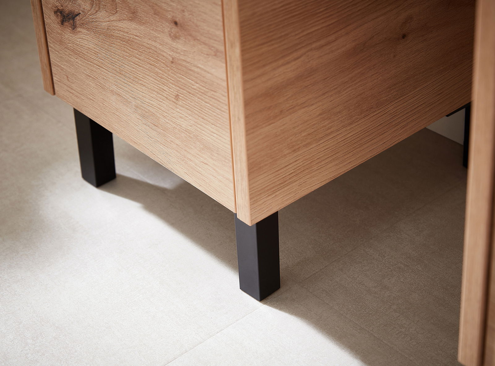 XORA Fuß-Set, 2-teilig XO1000 Nahaufnahme eines Möbelstücks mit Holzoberfläche und schwarzen Metallfüßen, seitliche Perspektive