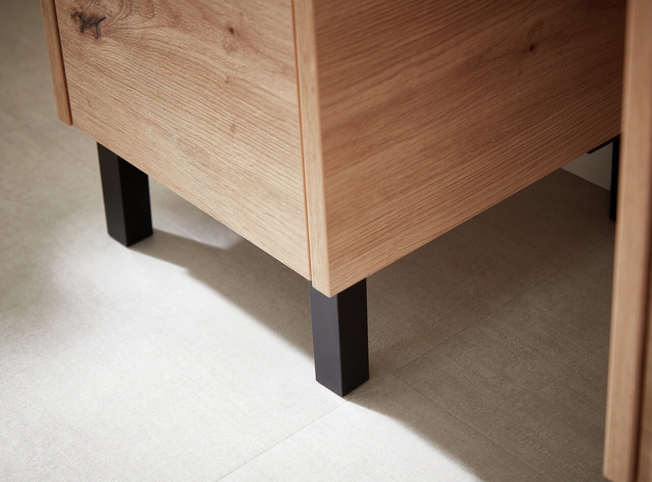 XORA Fuß-Set, 2-teilig XO1000 Nahaufnahme eines Möbelstücks mit Holzoberfläche und schwarzen Metallfüßen, seitliche Perspektive