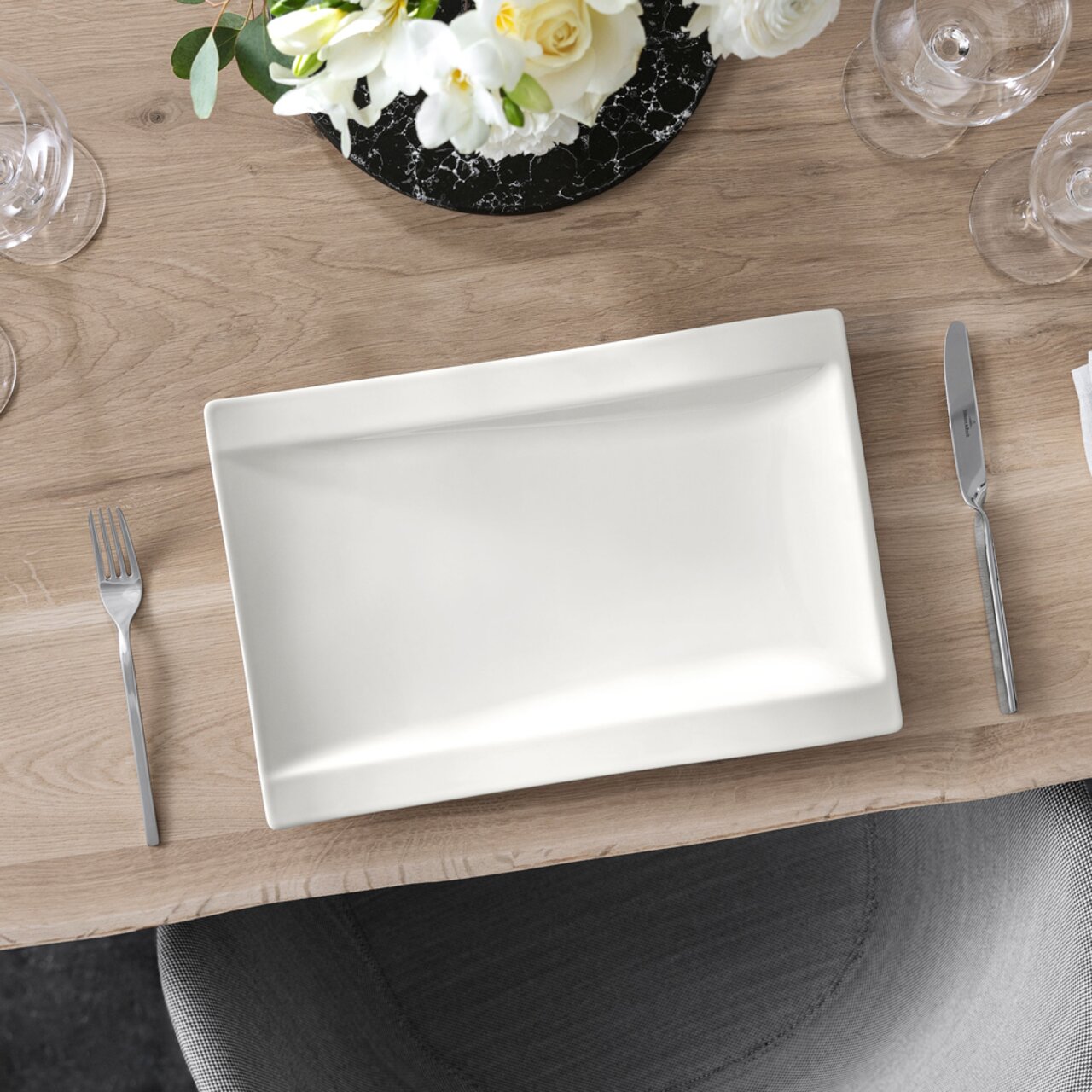 Villeroy & Boch Gourmetteller NEW WAVE Rechteckiger Gourmetteller 37x25cm NewWave auf einem gedeckten Tisch, von oben betrachtet, umgeben von Besteck und einem Blumenarrangement.