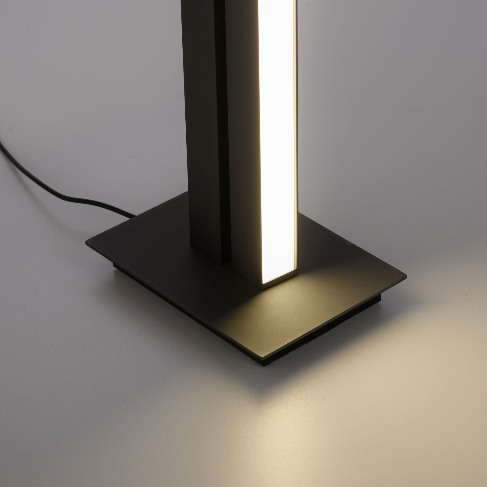 Nahaufnahme der Stehleuchte PURE-LINES von Paul Neuhaus mit leuchtendem vertikalen Lichtstreifen auf rechteckigem Sockel.