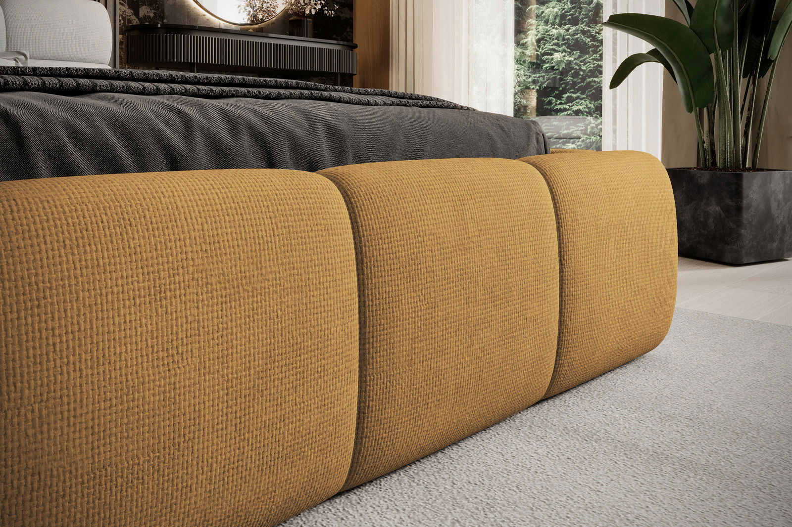 Nahaufnahme eines Polsterbettgestells in senfgelber Farbe, mit texturierter Oberfläche, von der Seite betrachtet.