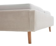 Nahaufnahme eines Polsterbettgestells mit hellbeigem, geripptem Stoffbezug und Holzbeinen, seitliche Perspektive