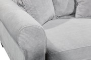 Nahaufnahme einer grauen, gerippten Sofaecke mit Armlehne und Kissen, seitliche Perspektive.