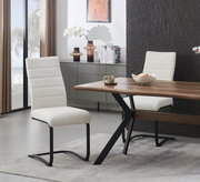 Moderner Freischwinger-Esszimmerstuhl mit hellbeigem Stoffbezug und schwarzem Metallgestell, seitliche Perspektive im Wohn-/Essbereich neben Holzesstisch.