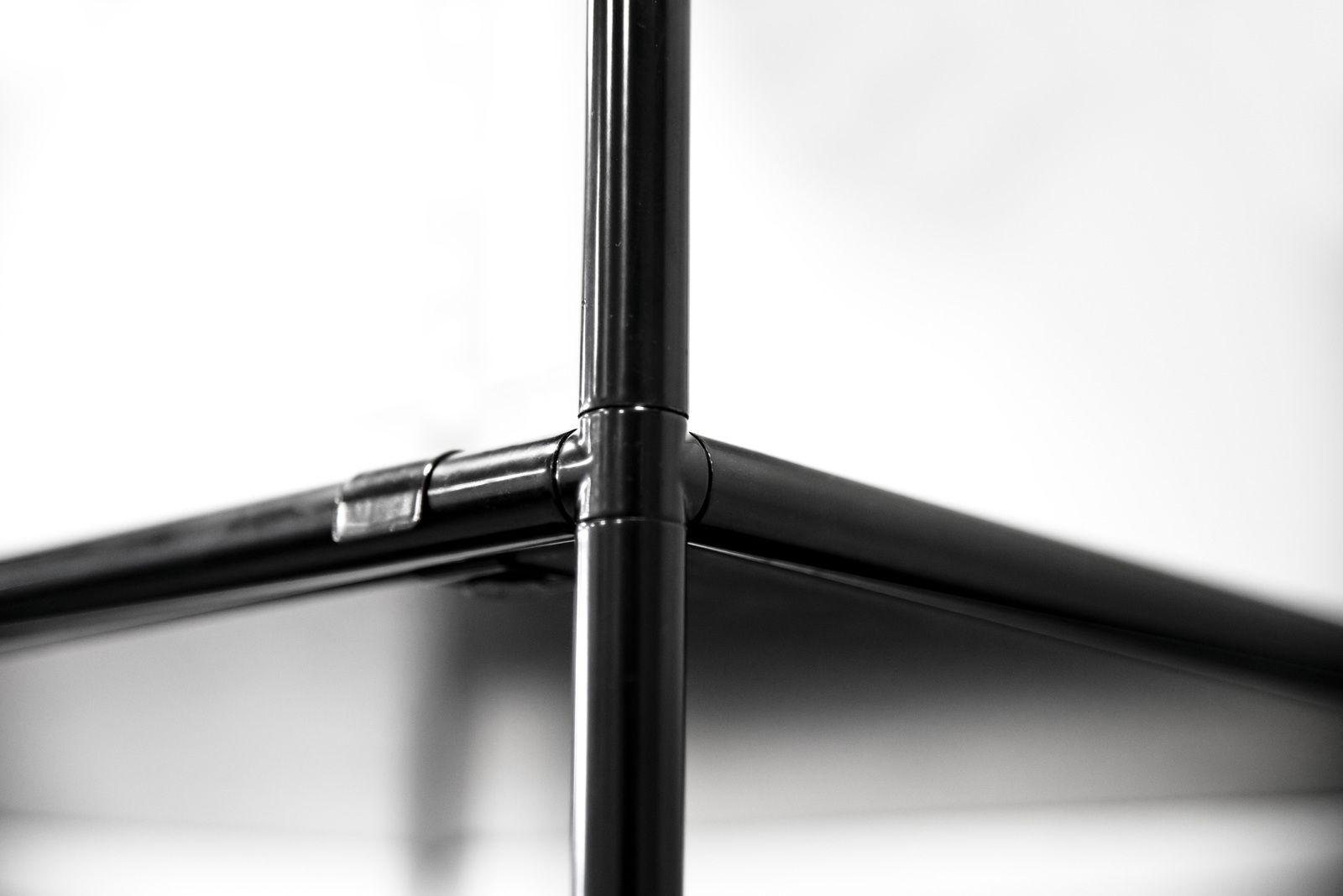 Nahaufnahme eines schwarzen Metallrahmens eines Highboards, perspektivisch von unten fotografiert.