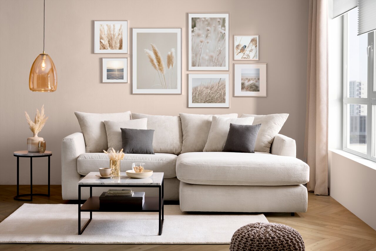 Gemütliche Rundecke in einem modernen Wohnzimmer, frontal betrachtet, mit beigen Kissen und einem Couchtisch.