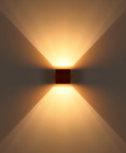 Moderne quadratische Wandleuchte in dunkler Holzoptik mit warmweißem Up-and-Down-Light, frontale Ansicht an heller Wand mit symmetrischem Lichtkegel nach oben und unten