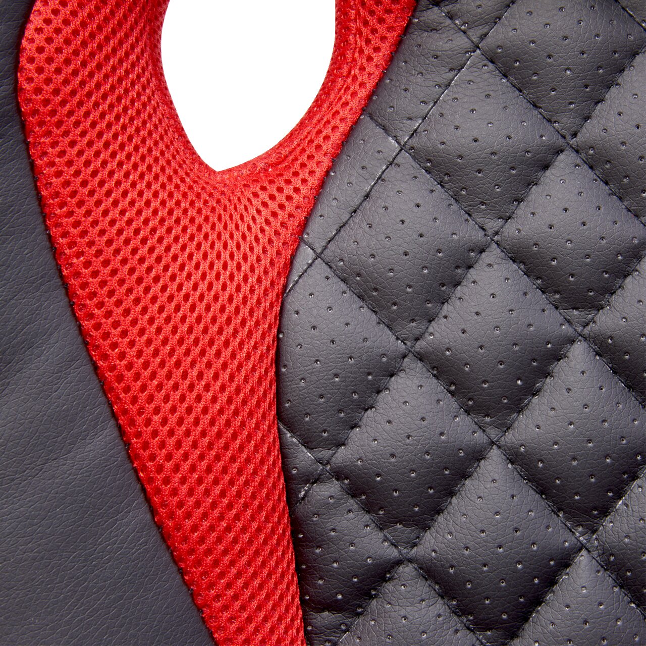 Nahaufnahme eines Gaming Stuhls mit schwarzem, gestepptem Kunstleder und rotem Netzstoff, seitliche Perspektive