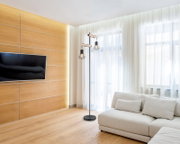 Moderne Stehleuchte mit zwei Käfiglampen in einem hellen Wohnzimmer, seitliche Perspektive