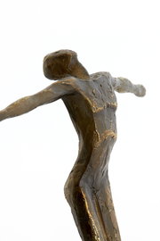 Bronzefarbene Skulptur eines stilisierten Menschen mit ausgestreckten Armen, seitliche Perspektive
