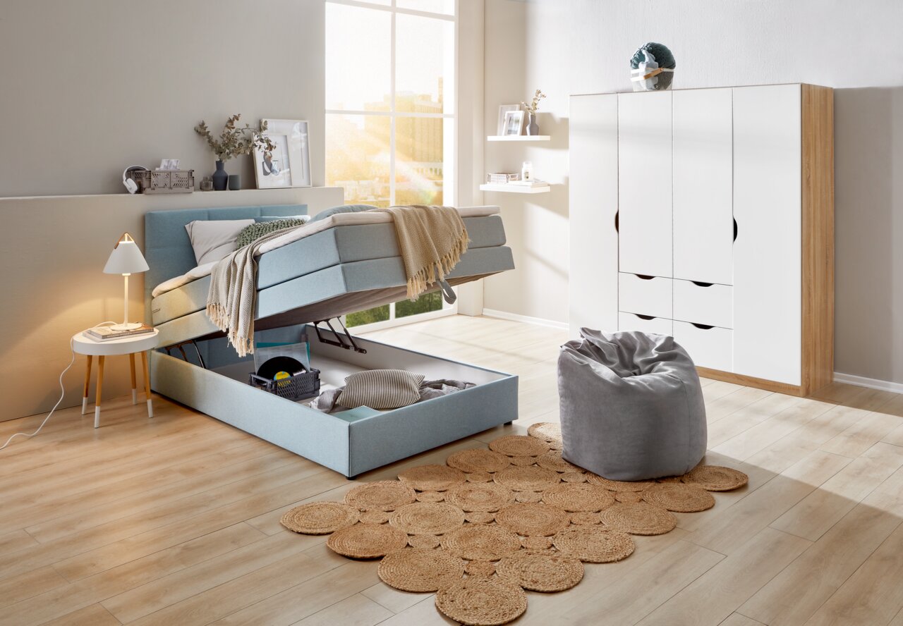 Boxspringbett mit Stauraum in einem modernen Schlafzimmer, seitliche Perspektive