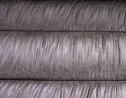 Nahaufnahme einer grauen, strukturierten Lederoberfläche einer Bank, von oben betrachtet.