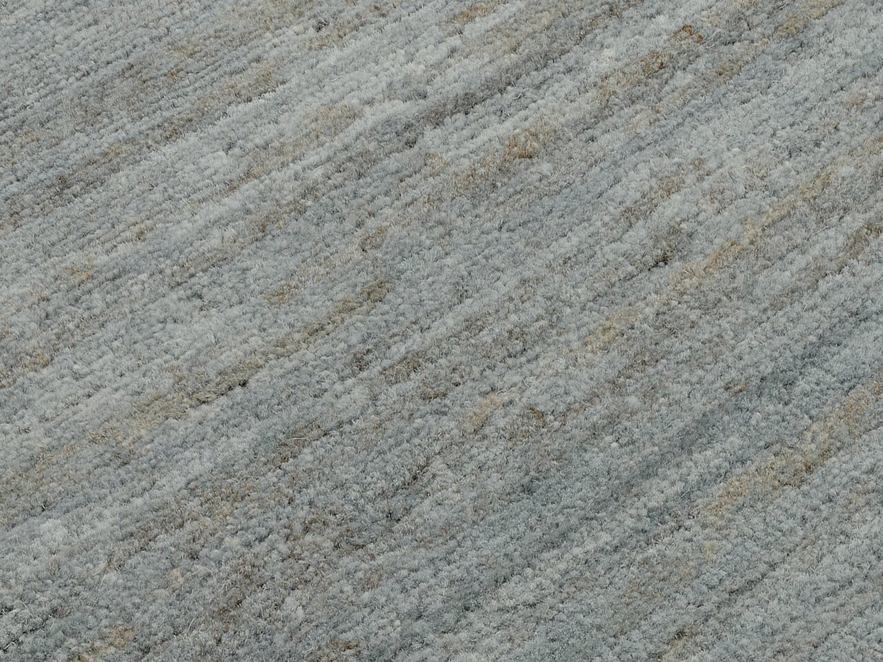 Nahaufnahme eines Wollteppichs mit grauen und beigen Streifen, diagonale Perspektive