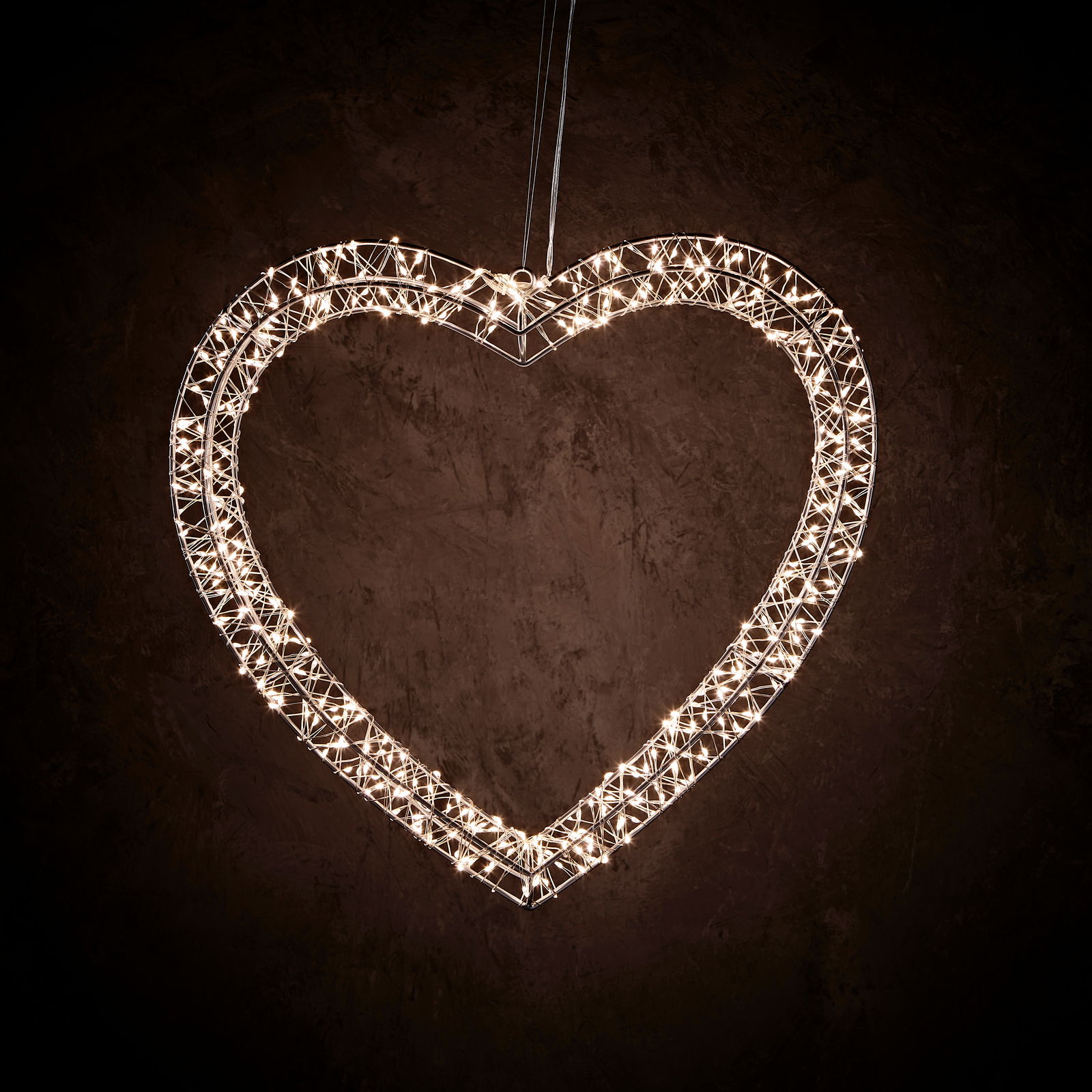 LED-Metallherz in Herzform, beleuchtet, hängend vor dunklem Hintergrund, Frontalansicht