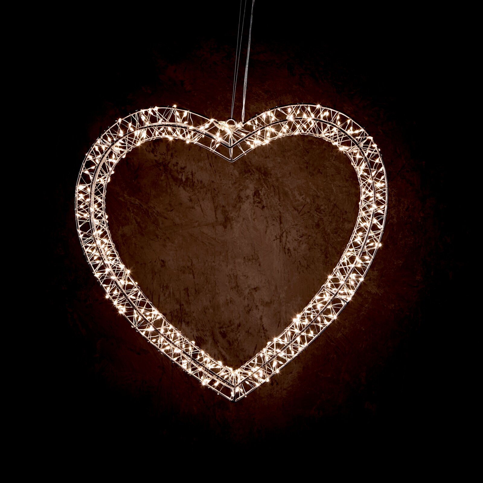Day LED-Metallherz LED-Metallherz in Herzform, beleuchtet, hängend vor dunklem Hintergrund, Frontalansicht