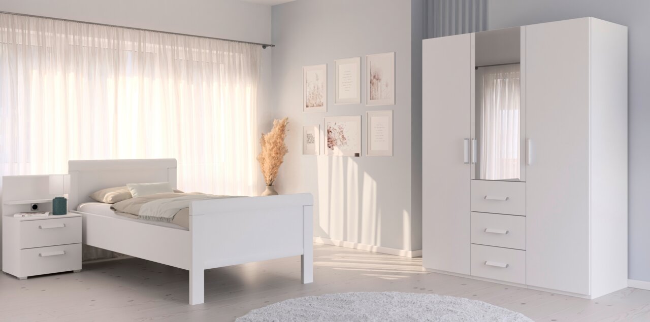 Komfortbett in einem hellen Schlafzimmer mit weißem Nachttisch und Kleiderschrank, seitliche Perspektive